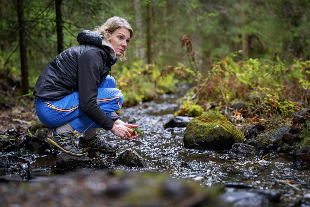 Frau am Bach bei Wanderung im Schwarzwald