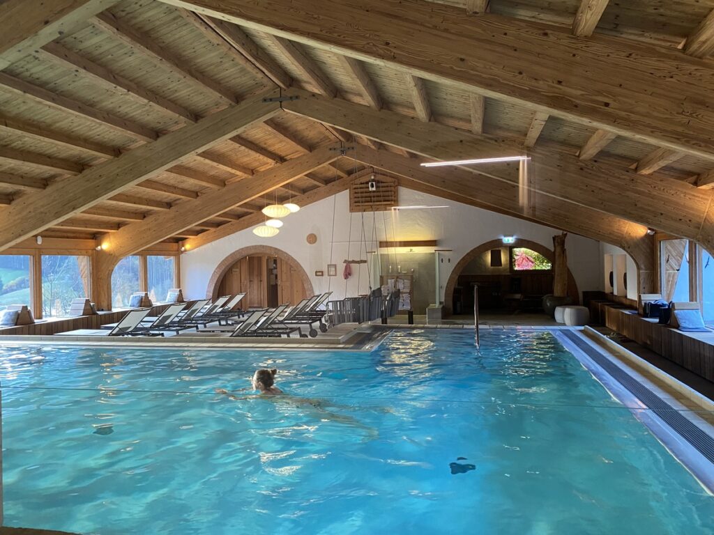Frau schwimmt im Innenpool vom Hotel Rehlegg
