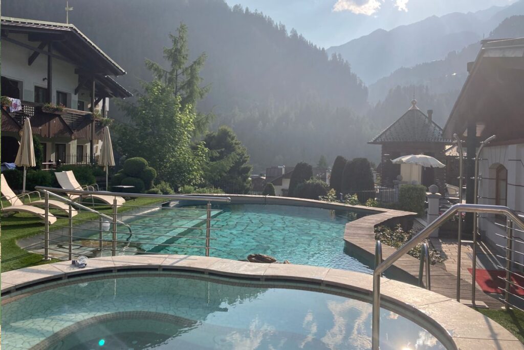 Wellness- und Aktivurlaub im Trentino: Außenpool im Wellnesshotel mit Blick auf die Berge