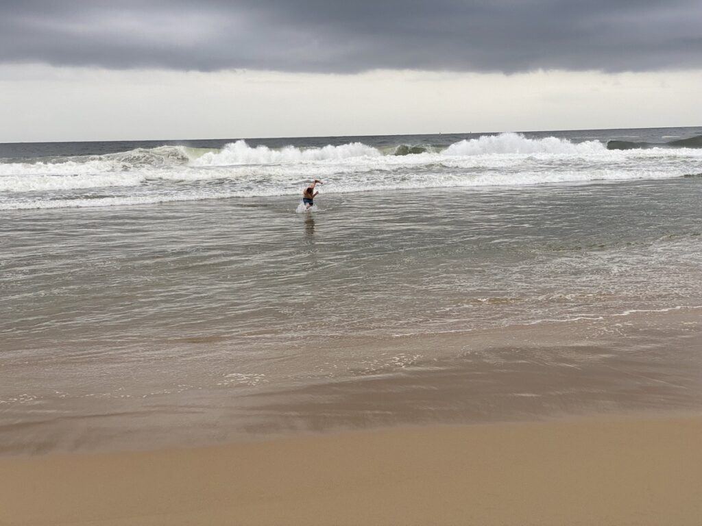 Mann badet im Meer am Strand von Kerala