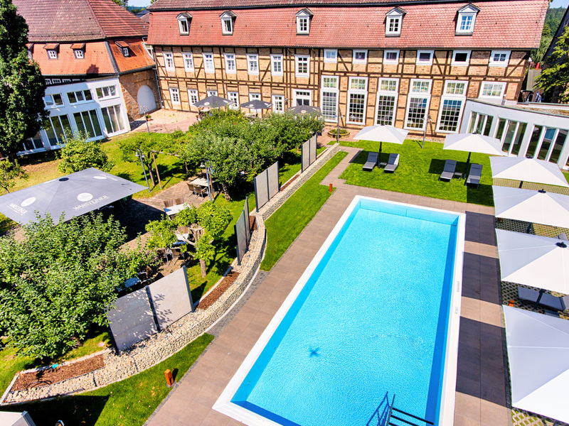 Großer Außenpool vor der Fachwerkfassade vom Welcome Hotel Bad Arolsen